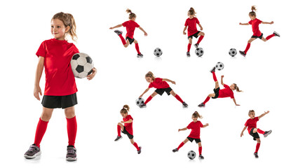 Full-length portrait of little girl, child, training, playing football isolated over white...