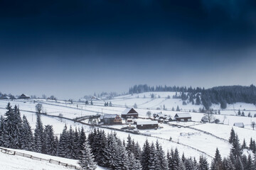 Nightime top view of remote village surrounded by snow