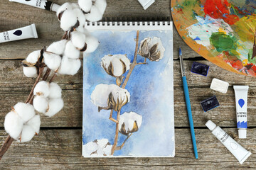 Painting of cotton flowers in sketchbook and art supplies on wooden table, flat lay