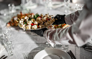 waiter holds plate with food. Restaurant service. buffet or catering.