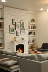 Stylish living room interior with comfortable sofa and decorative fireplace