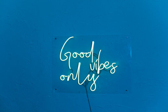 Neon words on the blue wall. Good vibes only neon sign at the bar, cafe or at home.