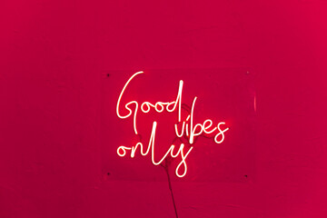 Neon words shining on the red wall. Good vibes only neon sign at the bar, cafe or at home. Viva Magenta trendy color of the year. - obrazy, fototapety, plakaty