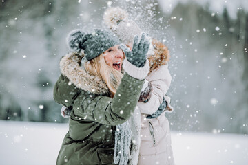 Family in winter forest blowing snow.