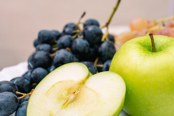 Sliced ​​juicy green apple on a festive table with ripe grapes