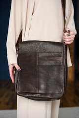 close-up photo of brown messanger leather bag on womans shoulder
