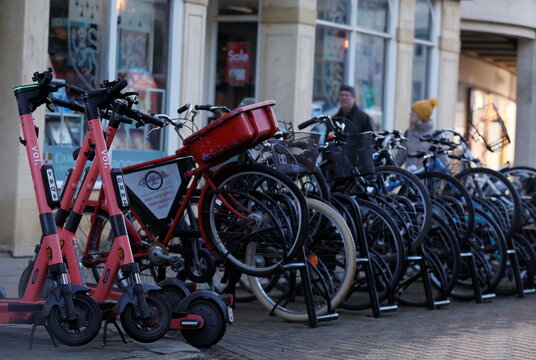 Electric scooters parked up with bicycles in Cambridge