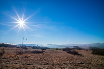 windräder im winter mit sonnenstern