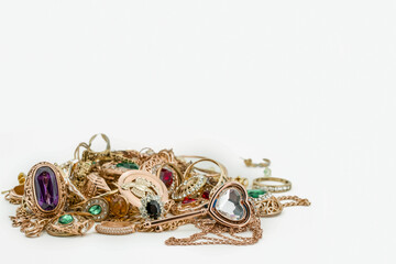 Pile of gold jewellery on white background