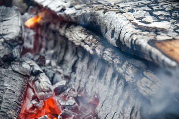 Burning firewood in the grill, bright coals and flames