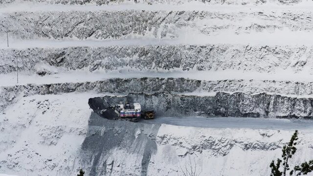 Open pit mine coal mining, dumpers, quarrying extractive industry stripping work. Big Yellow Mining Trucks. Boring machine is working in the open-cast mine.