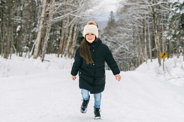 Fototapeta na wymiar Beautiful child girl outdoors in winter. Snowing. Winter atmosphere