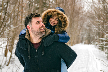 Handsome dad and his daughter are having fun outdoor in winter