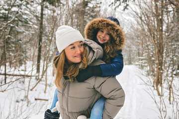 Handsome mother and his daughter are having fun outdoor in winter