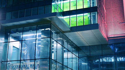 Amazing night cityscape. Office building at night, building facade with glass and lights. View with illuminated modern skyscraper. Scenic glowing windows of skyscrapers at evening. 