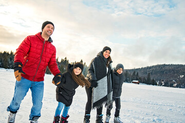 Happy family on ice skating on winter season lake