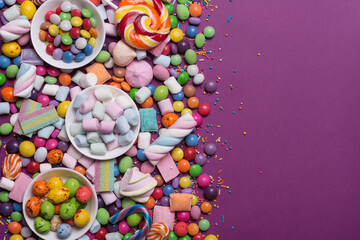 Fototapeta na wymiar Bright sweet multicolored dragee, candies, lollipops, marshmallows