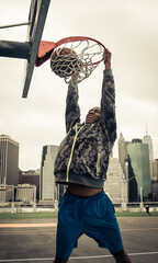 Huge slam dunk. Young american player playing basketball at the court in New york city