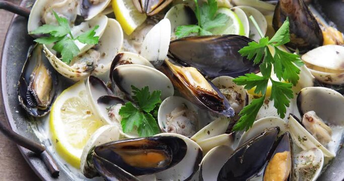 Mussels in a pan with parsley and lemon