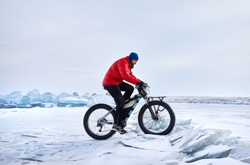 Man ride bicycle on the frozen lake.