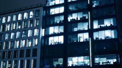 Amazing night cityscape. Office building at night, building facade with glass and lights. View with illuminated modern skyscraper. Scenic glowing windows of skyscrapers at evening. 