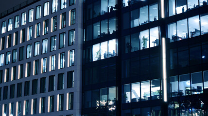 Obraz premium Amazing night cityscape. Office building at night, building facade with glass and lights. View with illuminated modern skyscraper. Scenic glowing windows of skyscrapers at evening. 