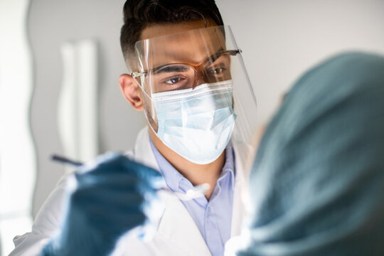 Closeup Shot Of Arab Male Dentist Examining Muslim Female Patient's Teeth