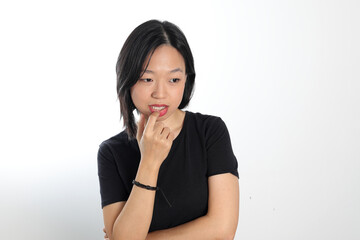 Young attractive south east asian woman pose face expression emotion on white background think finger in mouth