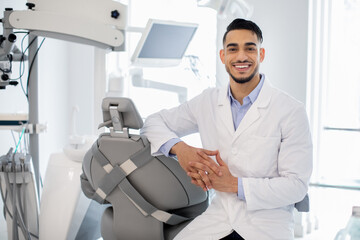 Naklejka na ściany i meble Dental Services. Portrait Of Professional Arab Stomatologist Doctor Posing At Workplace