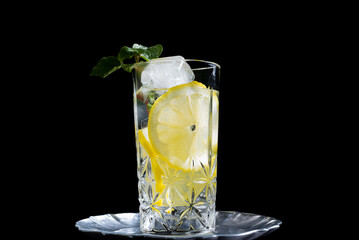 Un vaso de refrescante zumo de limón, cóctel de frutas con rodajas de limón y hielo sobre fondo...