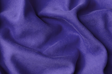 Fototapeta na wymiar Fabric with waves colored in violet color of the year 2022. Trendy color very peri. Fabric backdrop, cloth texture, view from above.