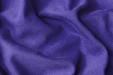 Fabric with waves colored in violet color of the year 2022. Trendy color very peri. Fabric backdrop, cloth texture, view from above.