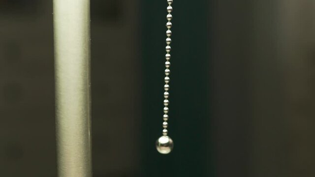 Close-up of Girl Hand Pulling Cord from Floor Lamp, Girl Turns on Light, Light Turns On in the Room, Closeup. Turning on Floor Lamp.