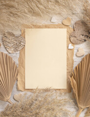 Blank card on white wooden table near dried pampas grass and hearts, Boho mockup