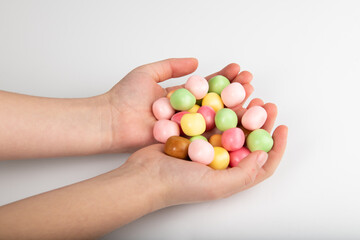 Child holding candy in his hands on white background