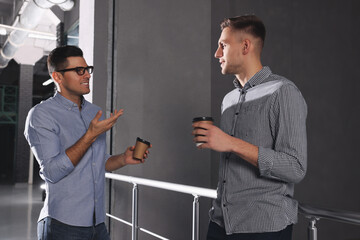 Coworkers talking during coffee break in office