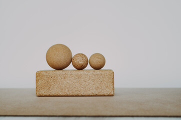 Three cork massage balls for fascia on a cork block on a cork yoga mat. Concept: eco friendly and biodegradable props for self care at home