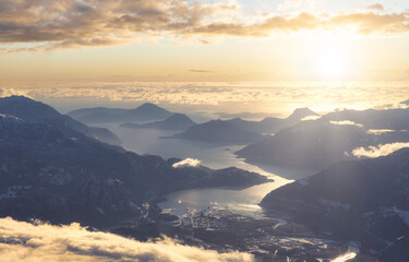 Aerial View of a small city, Squamish, in Howe Sound during winter season. Sunst Sky Art Render....
