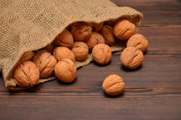 nuts in a sack of burlap on a wooden background close-up