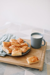 freshly baked homemade pastry on kitchen table. breakfast with puff buns and a glass of milk