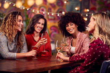 Multi-Cultural Group Of Female Friends Enjoying Party Night Out In Bar