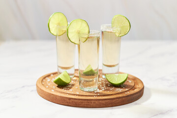 Set of tequila shots on wooden board. Mexican alcoholic drink.