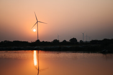 View of the sunset at the lake with windmills on the hills at Wankaner, Gujarat, India