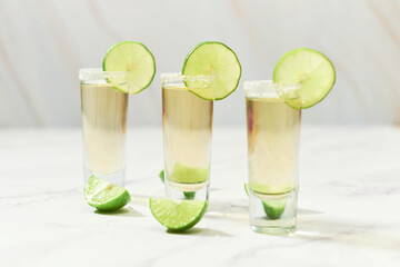 Three traditional tequila shots with lime and salt. Mexican tradition.