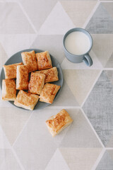 freshly baked homemade pastry on kitchen table. breakfast with puff buns and a glass of milk