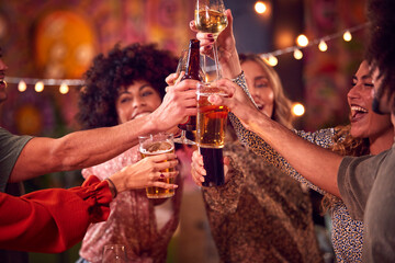 Multi-Cultural Group Of Friends Enjoying Night Out Drinking In Bar Together Making A Toast