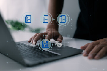 A man uses a computer to manage his family's company, keep track of records, paperwork, and keep track of revenue and costs.