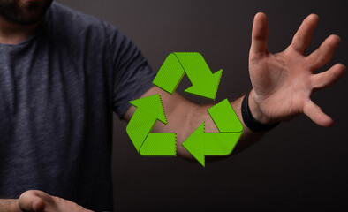 hand holding green recycle symbol