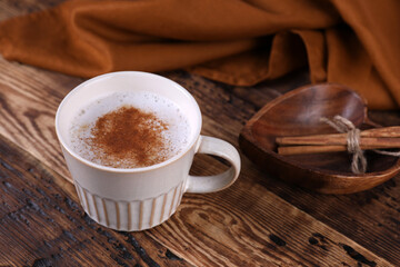 Coffee with cinnamon on a wooden table