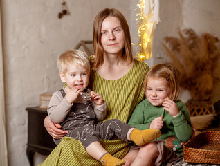 Mom with son and daughter in the room, a good family, a woman hugs a girl and a boy.
